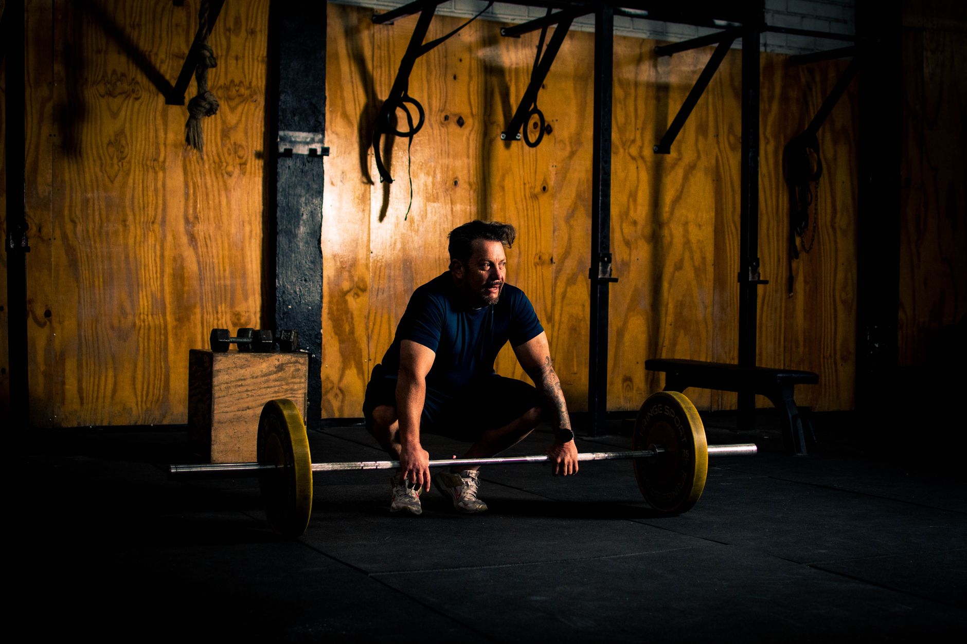 Heavy-duty barbell loaded with weight plates in a home gym setting