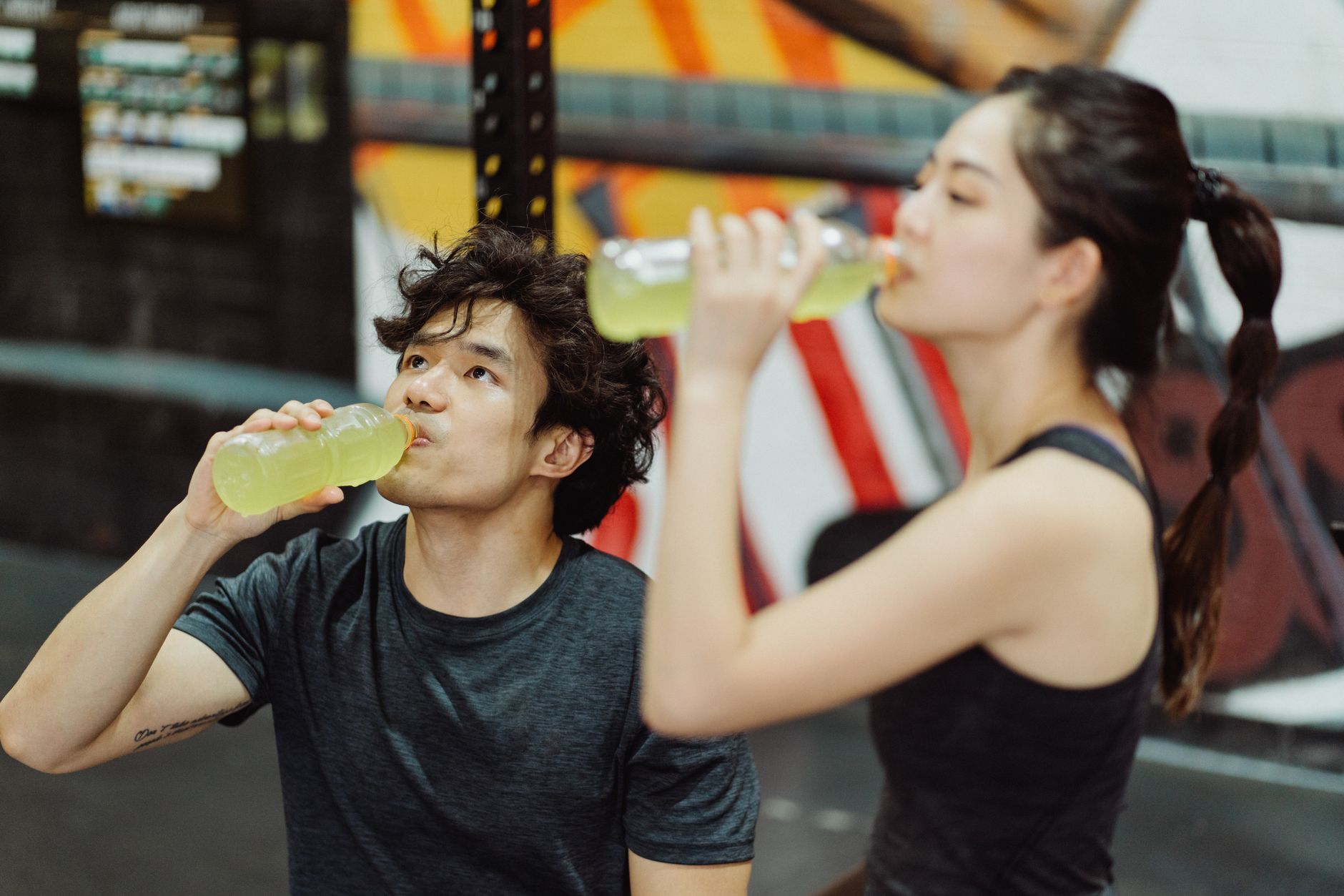 A person pouring electrolyte powder into a shaker bottle.