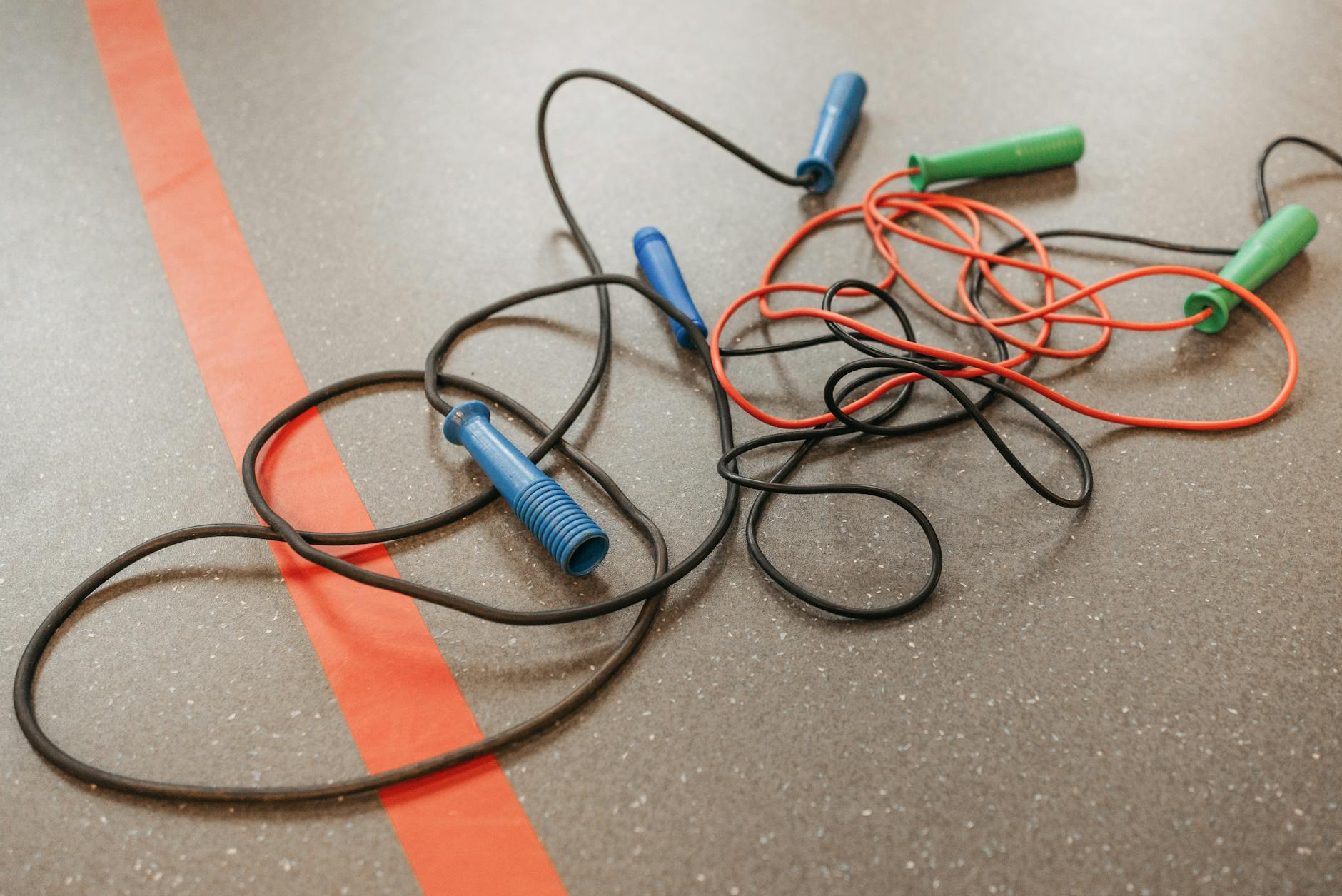 A CrossFit athlete performing double unders with a speed rope, blurred background of a gym. Best jump rope 2026.