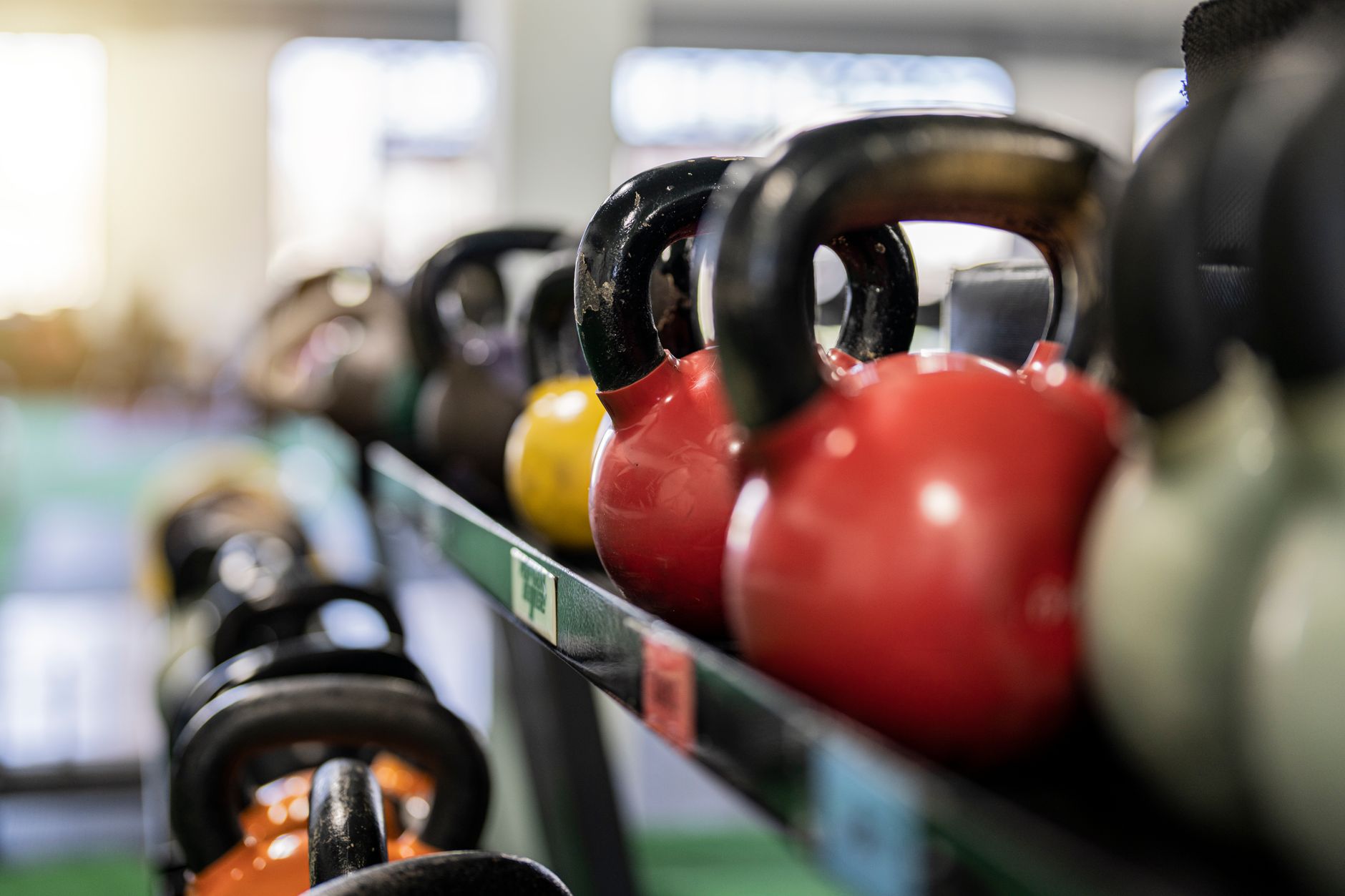 A person performing a kettlebell swing with a cast iron kettlebell.