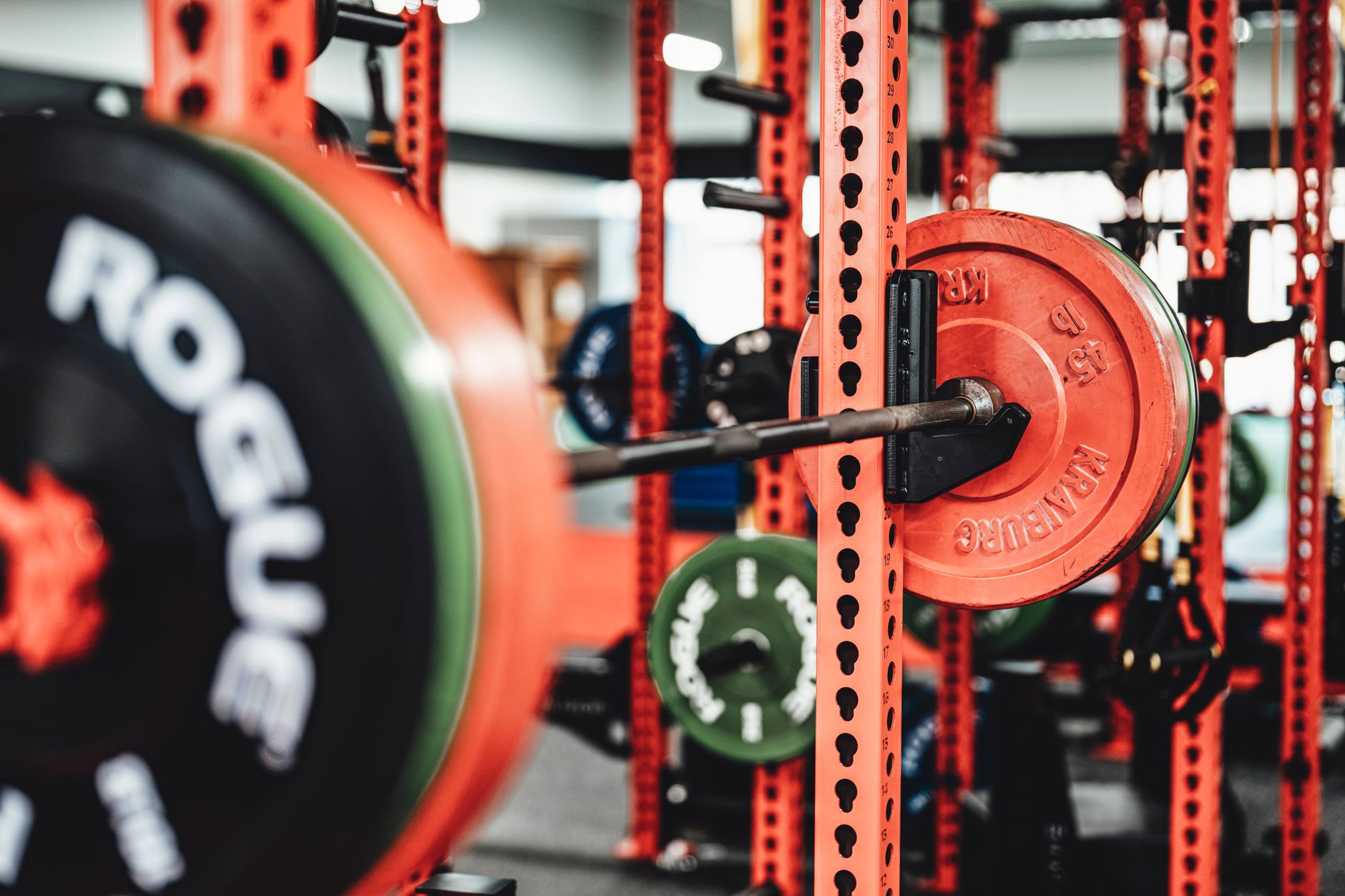 Man lifting weights inside a sturdy power rack in a home gym.