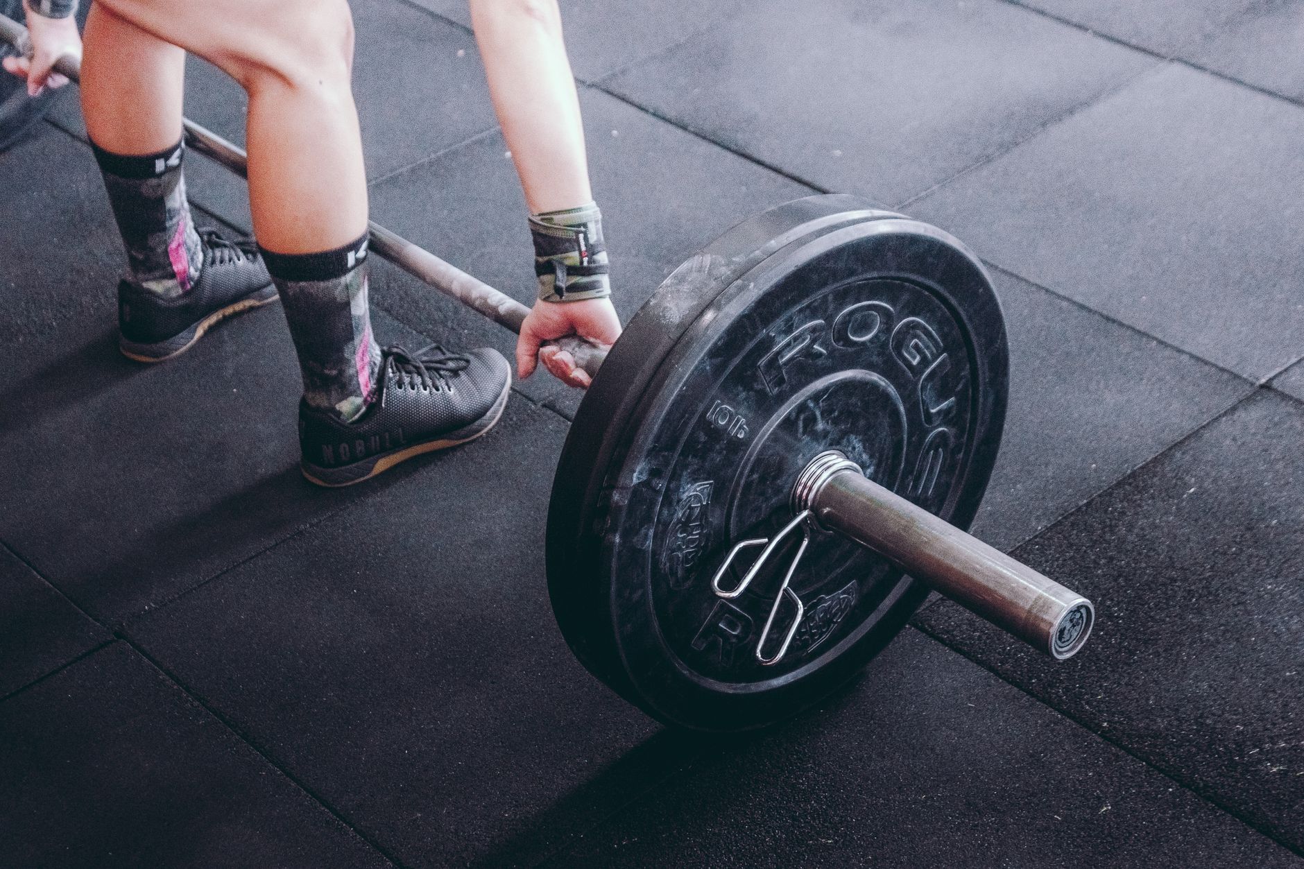 Person's wrists wrapped with lifting straps during a bench press.