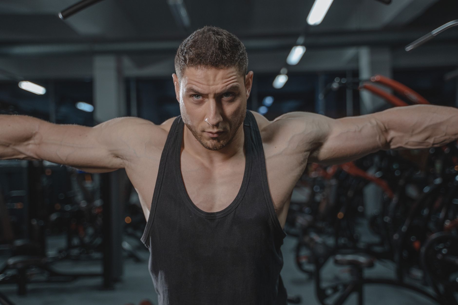 Man performing shoulder press with heavy dumbbells for mass