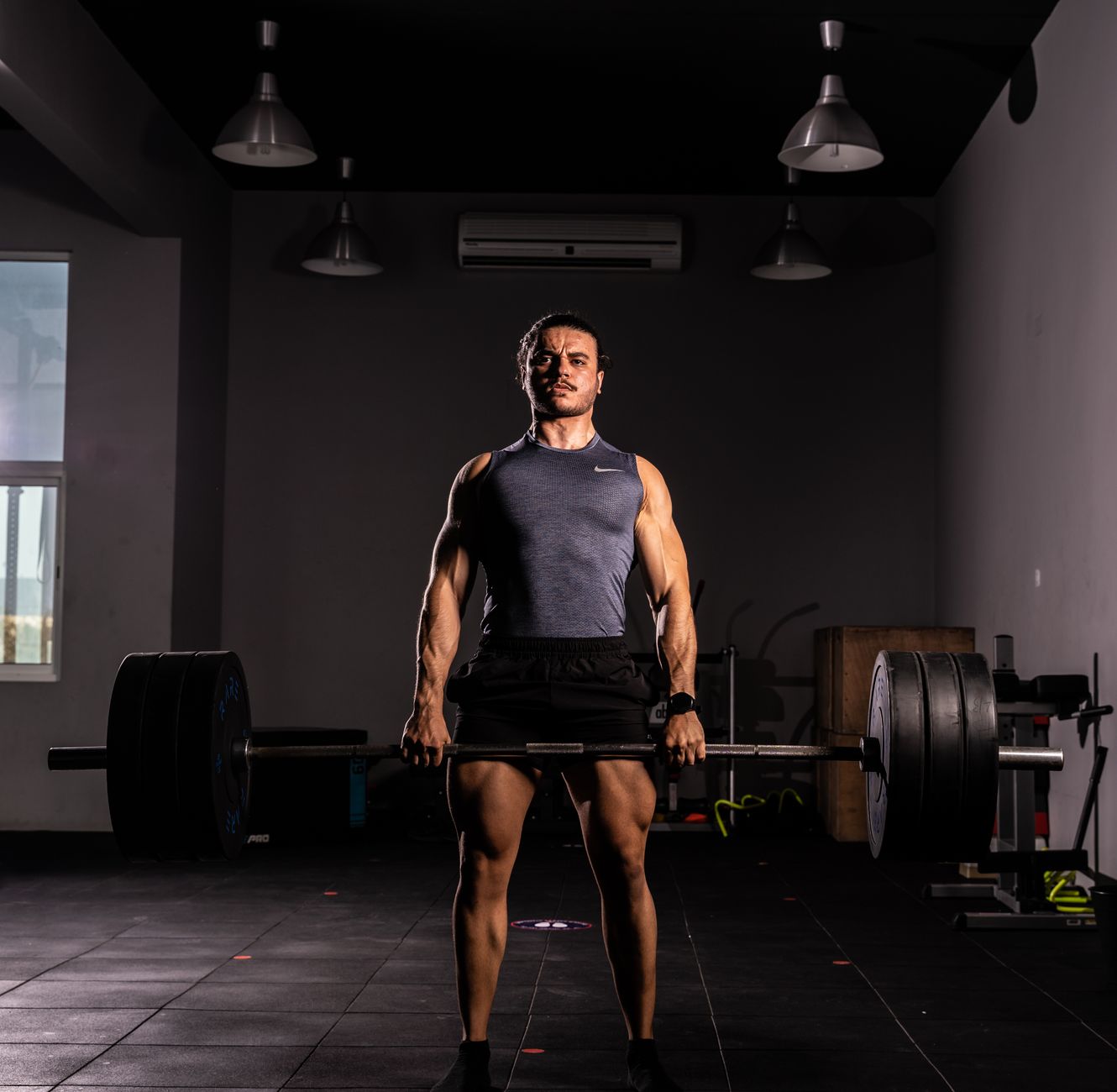 A strong lifter performing a heavy conventional deadlift with a barbell.