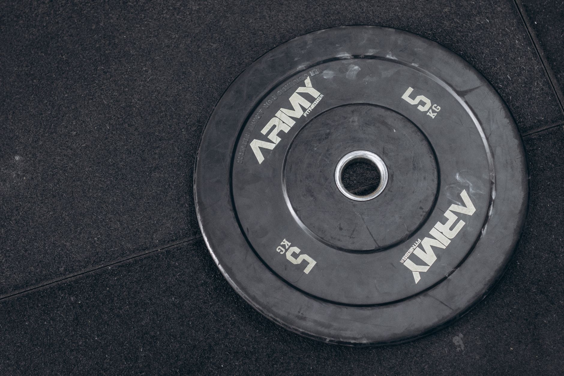 A man performing a dumbbell bench press in a home gym.