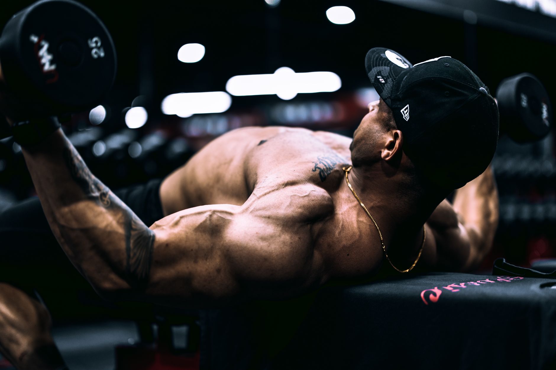 Man intensely bench pressing heavy weight in a gym.