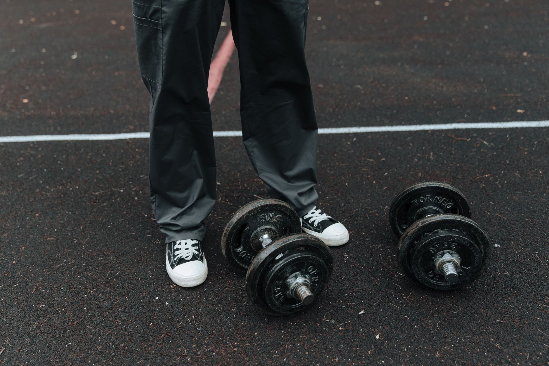 Man performing a heavy barbell back squat in a home gym, focusing on leg day for mass.